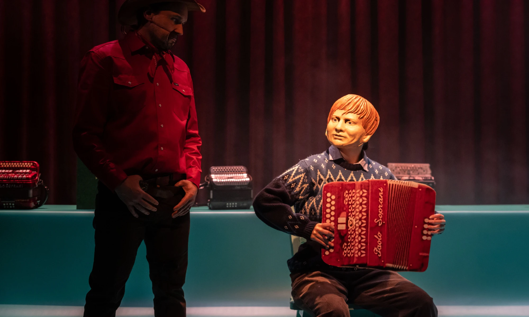 Photo of two actors from Bellow on stage - one masked. 