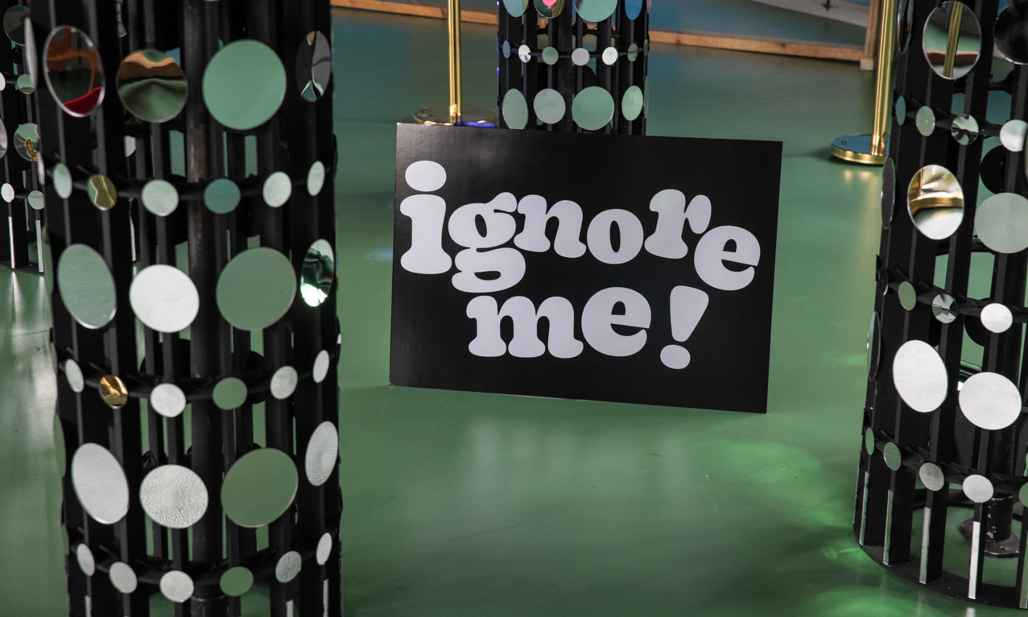 Close up photo of legs of elephant sculpture with sign saying ignore me