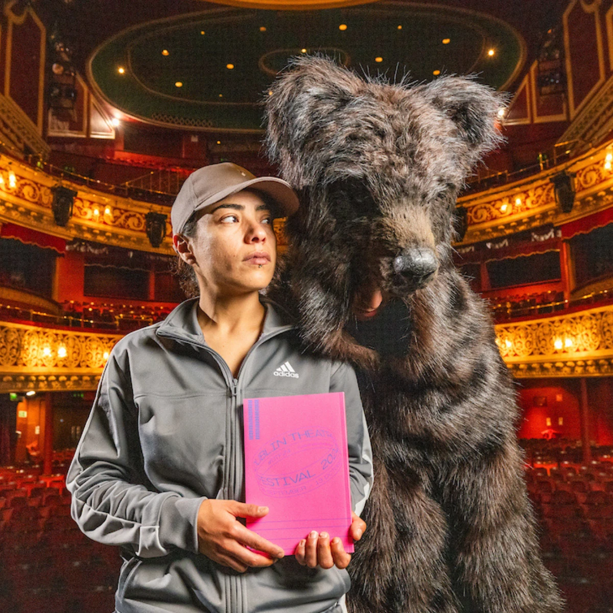 Photo of man in bear costume and actor in a theatre.