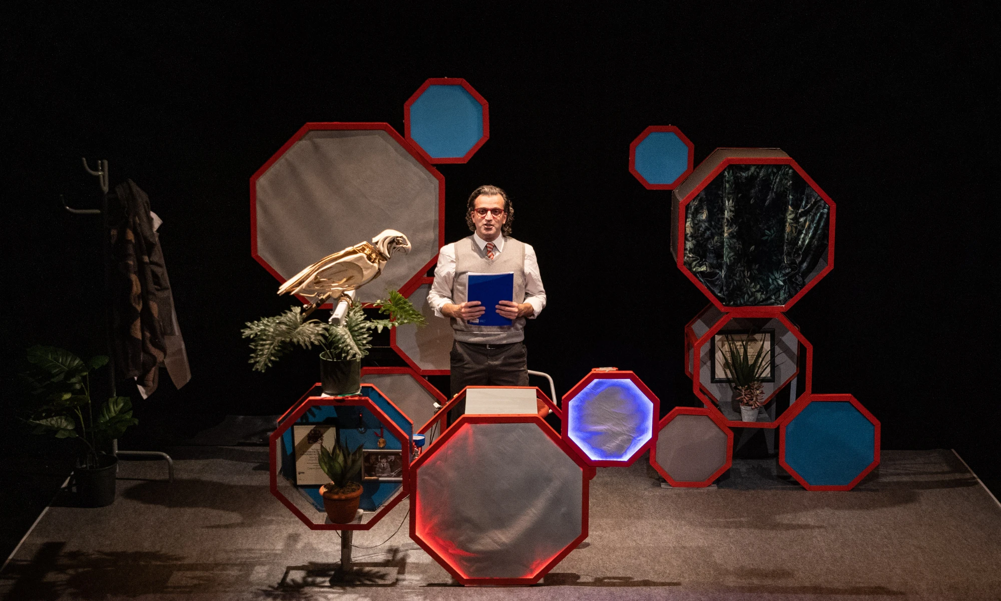 Photo of set with actor, wooden parrot and set design.