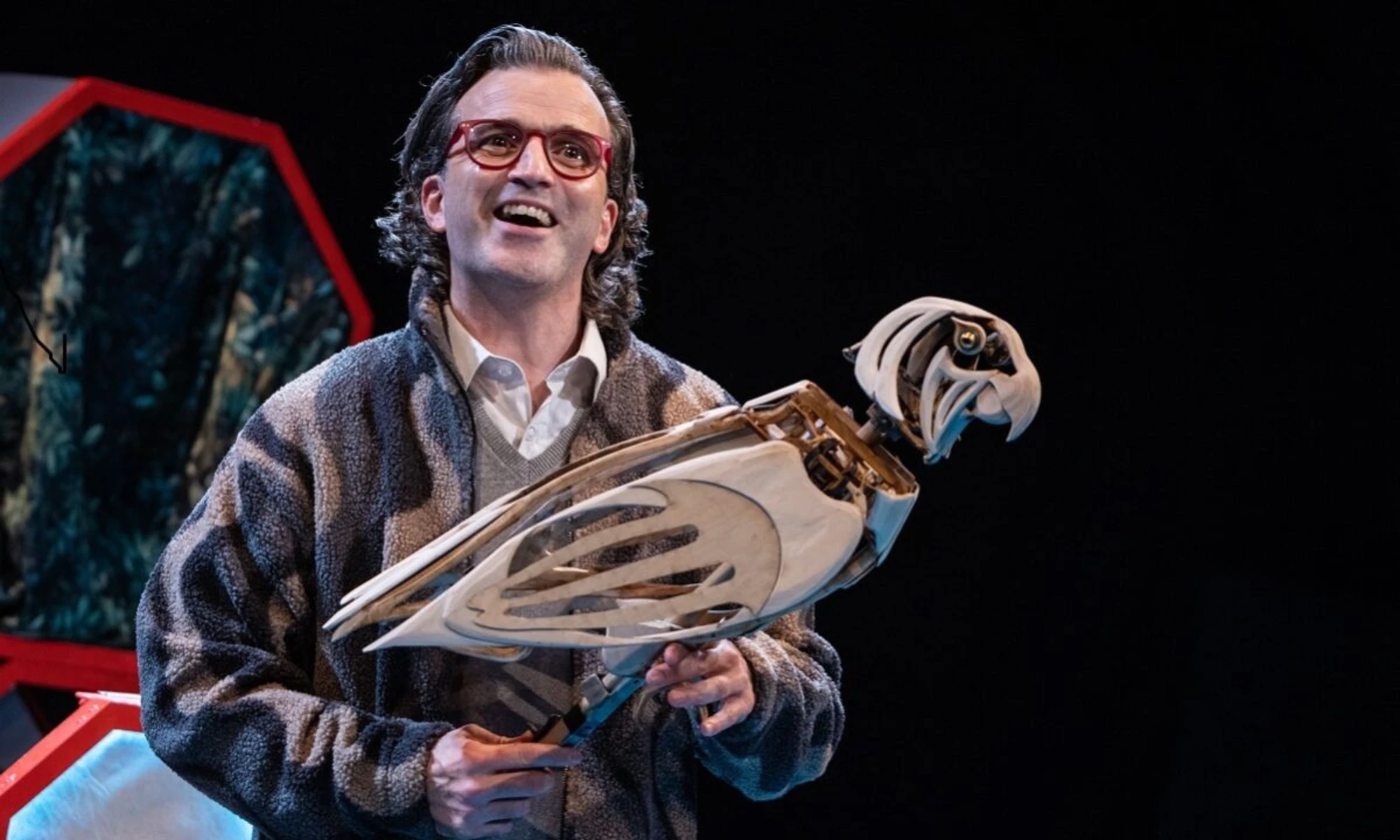 Photo of actor holding wooden parrot on stage