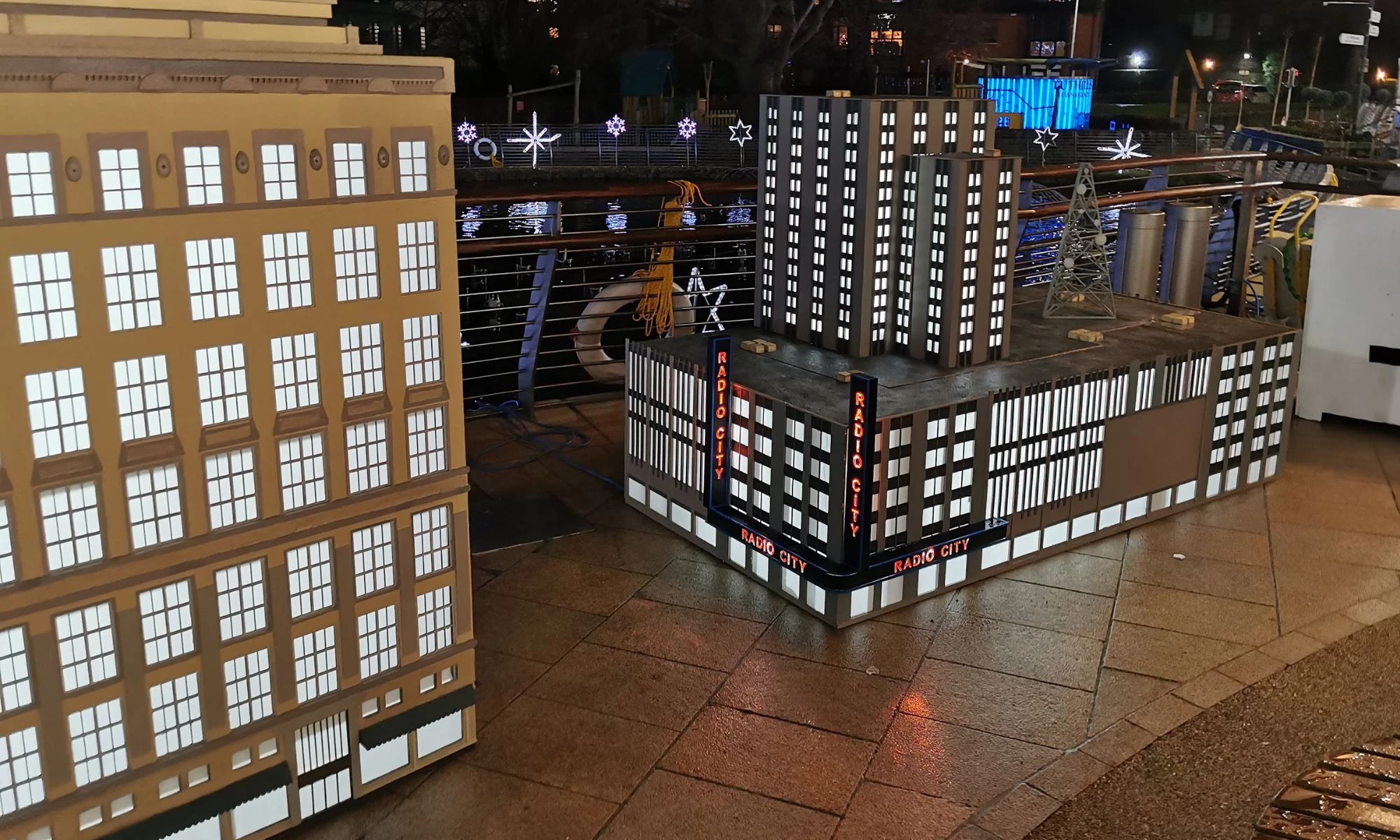 Miniature models of two New York buildings on flagstones.