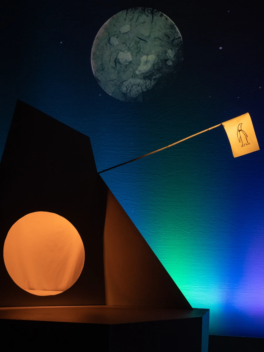Photo of a stage set with the moon and little flag