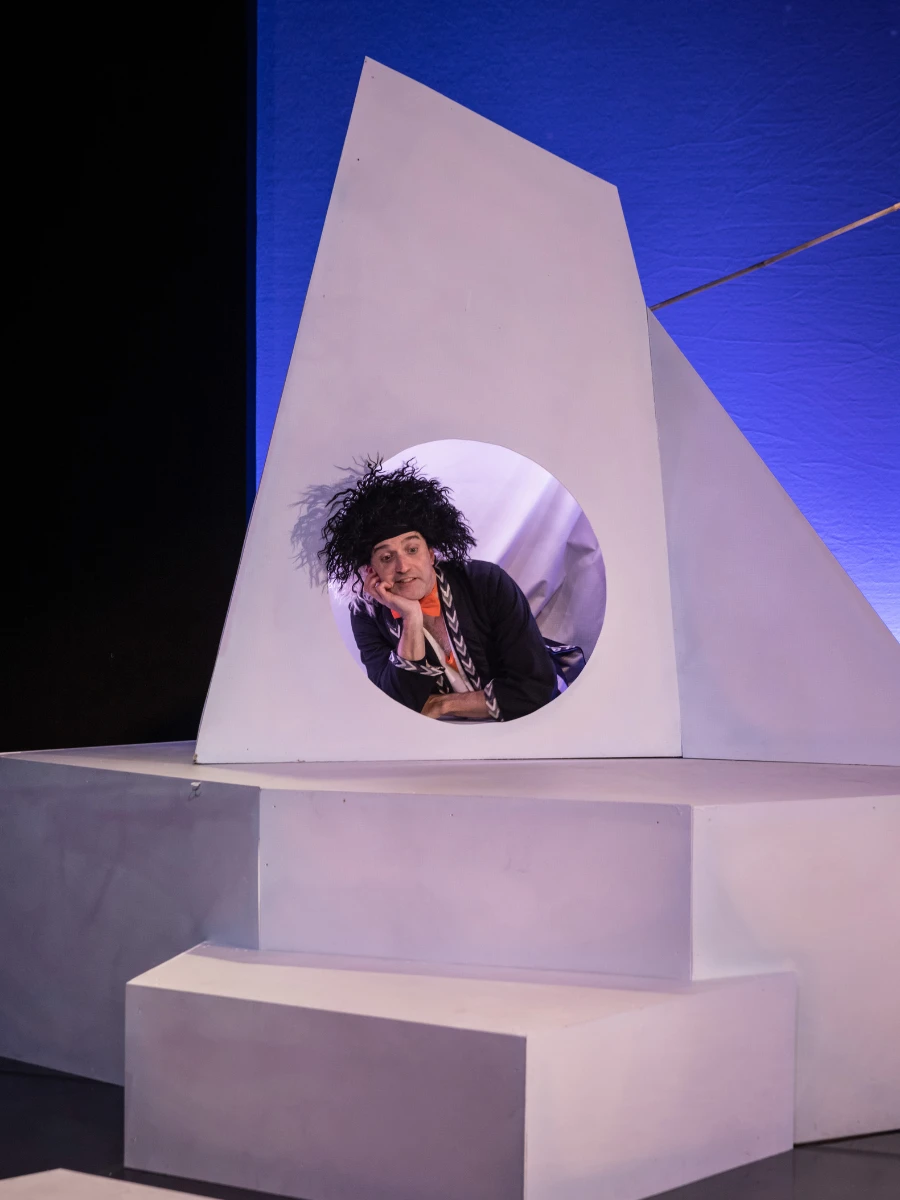 Photo of a man in a white stage set