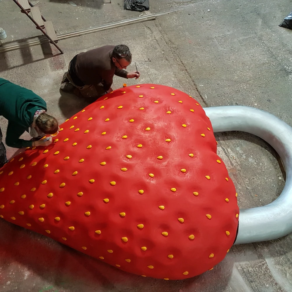 Photo of two people working on giant strawberry keyring - specialist prop