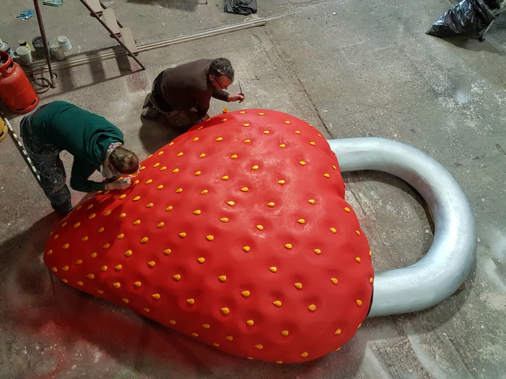 Photo of two people working on giant strawberry keyring - specialist prop